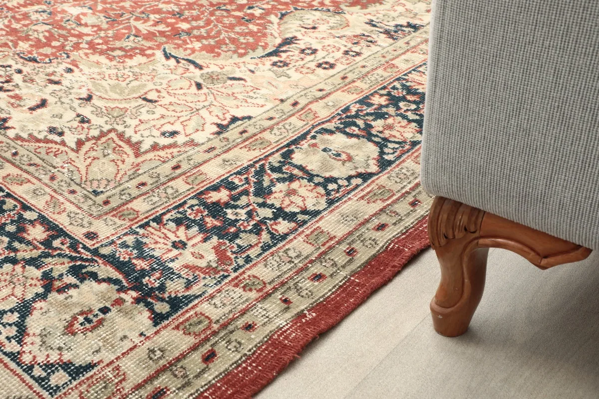 Rug placed next to a sofa leg, showing how it fits into a living area