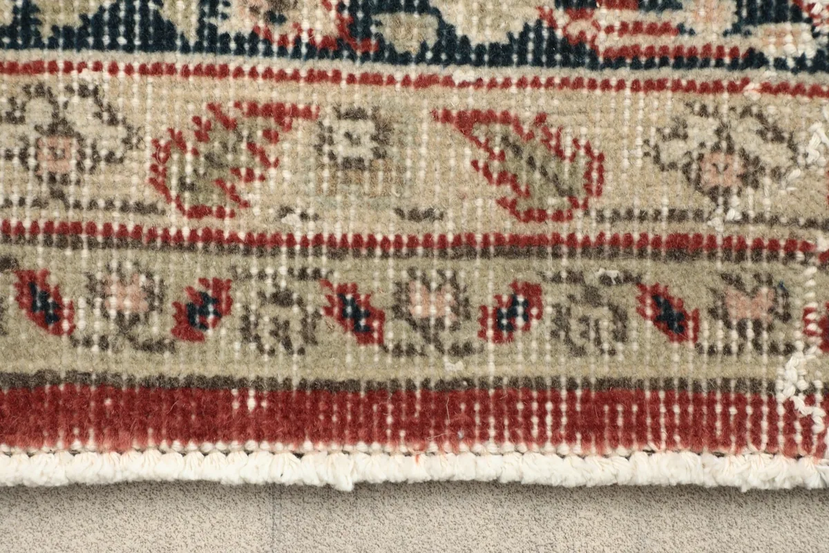 Close-up detail of the rug's border design and fringe