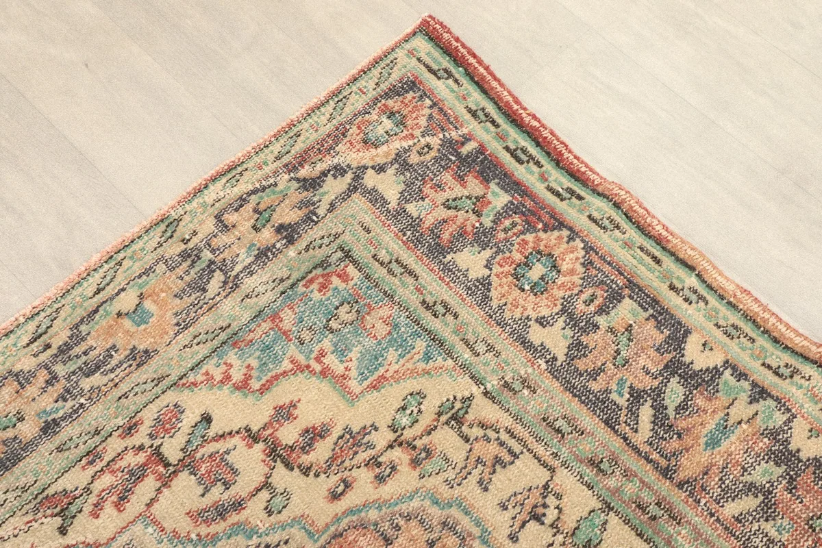 Close-up view of the corner of the rug, showing the intricate border patterns and colors.