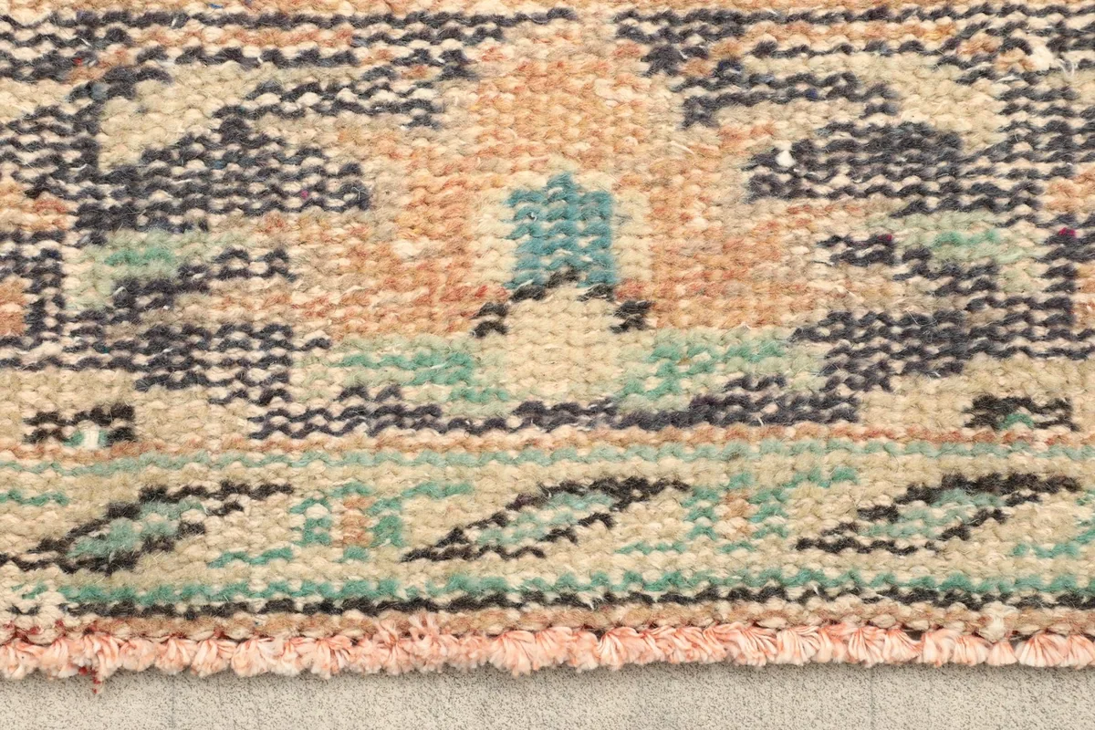Detailed shot of the rug's low pile and knotting, highlighting the texture and color variations.