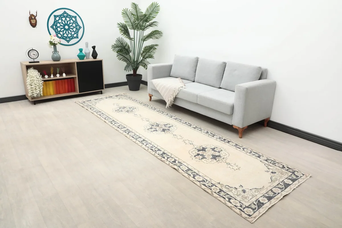 Long view of the ivory and navy runner rug in a room with a sofa and minimalist decor.