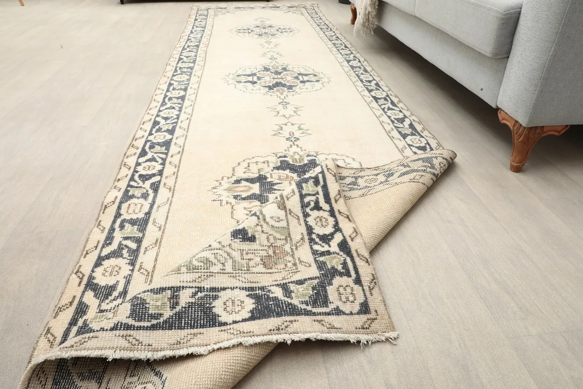 The runner rug partially unrolled in a room setting, displaying its full length and pattern.
