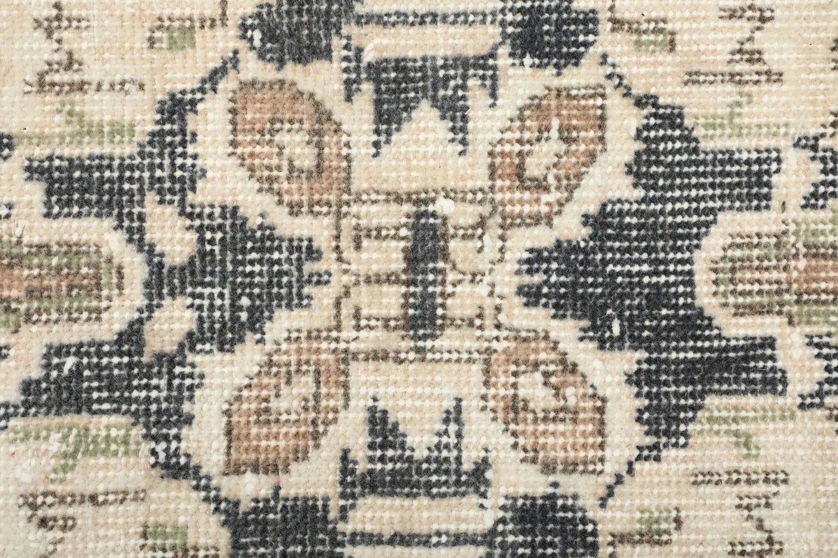 Macro shot of the wool pile, revealing the hand-knotted texture and distressed appearance of the fibers.