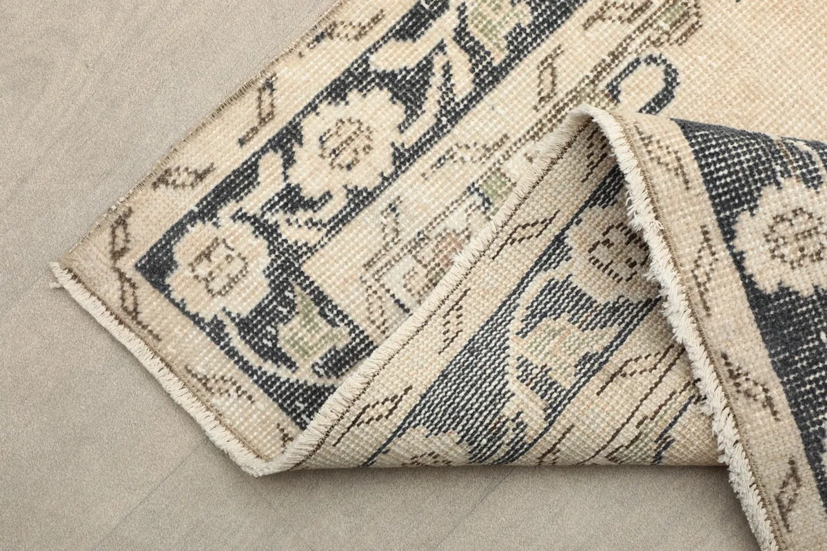 A folded section of the rug, showing the reverse side and the construction of the border.