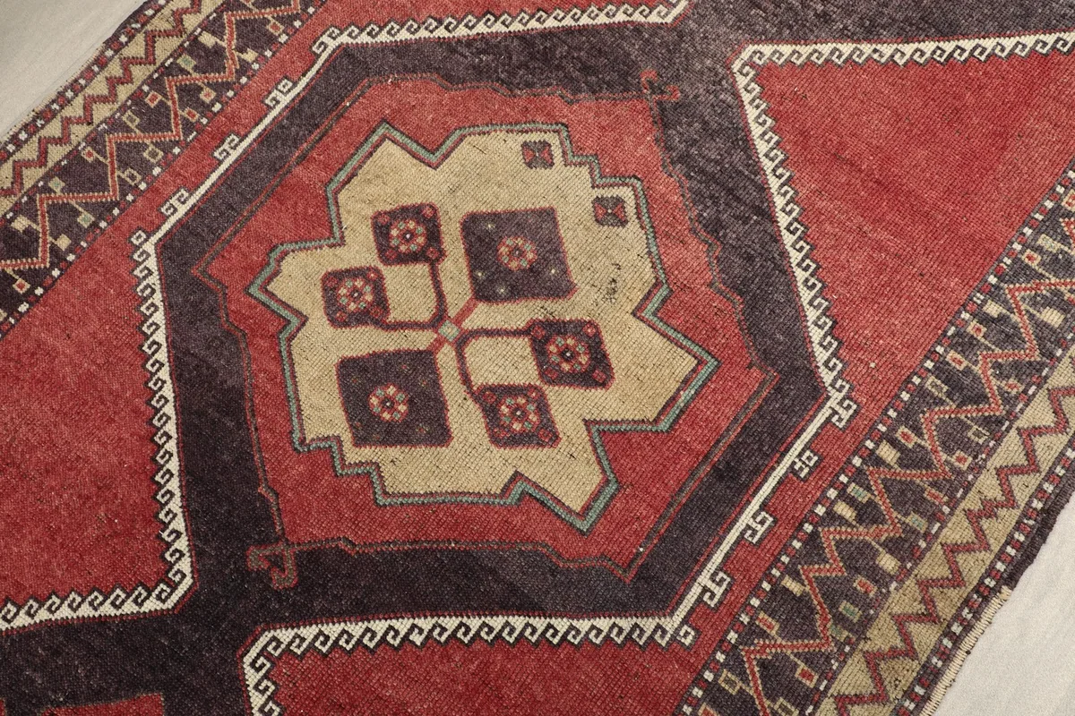 Close-up of a beige and charcoal geometric motif within the runner's central design, showing wool texture.