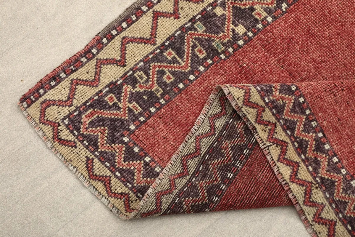 Another view of the folded corner, emphasizing the rug's border design and the quality of the wool material.