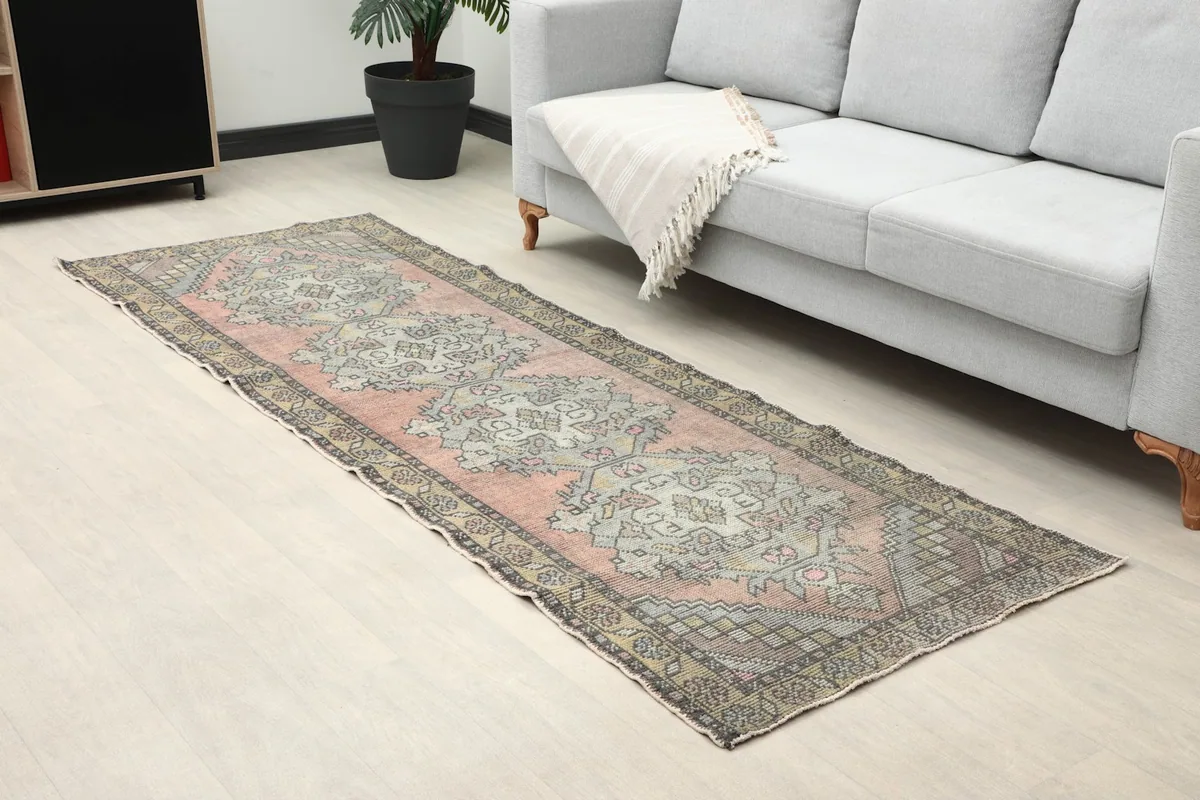 Angled view of the rose runner in a living space, highlighting its placement by a sofa.