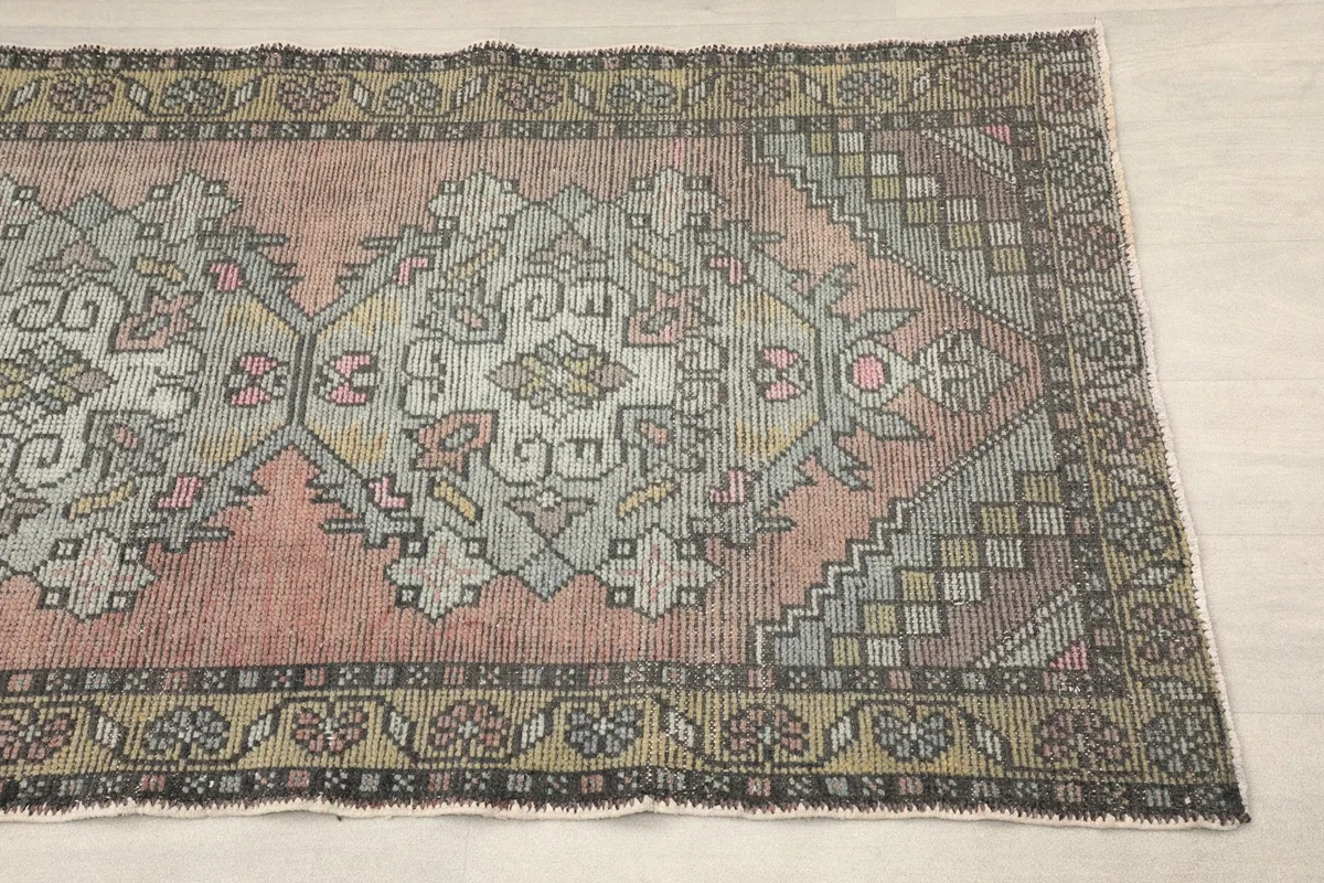 Close-up detail of one end of the rose runner, showing the geometric patterns and border design.
