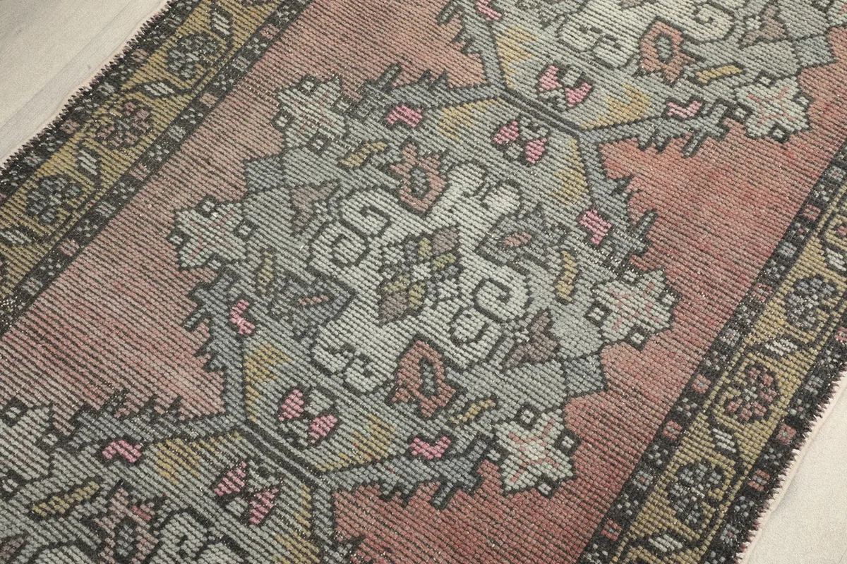 Detailed view of the central geometric medallion and surrounding patterns on the rose runner.