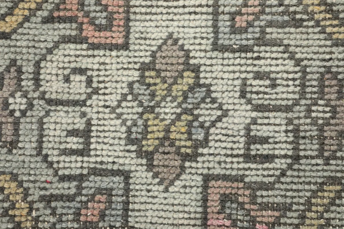 Macro view of the low wool pile, showing the texture and hand-knotted construction of the rug.