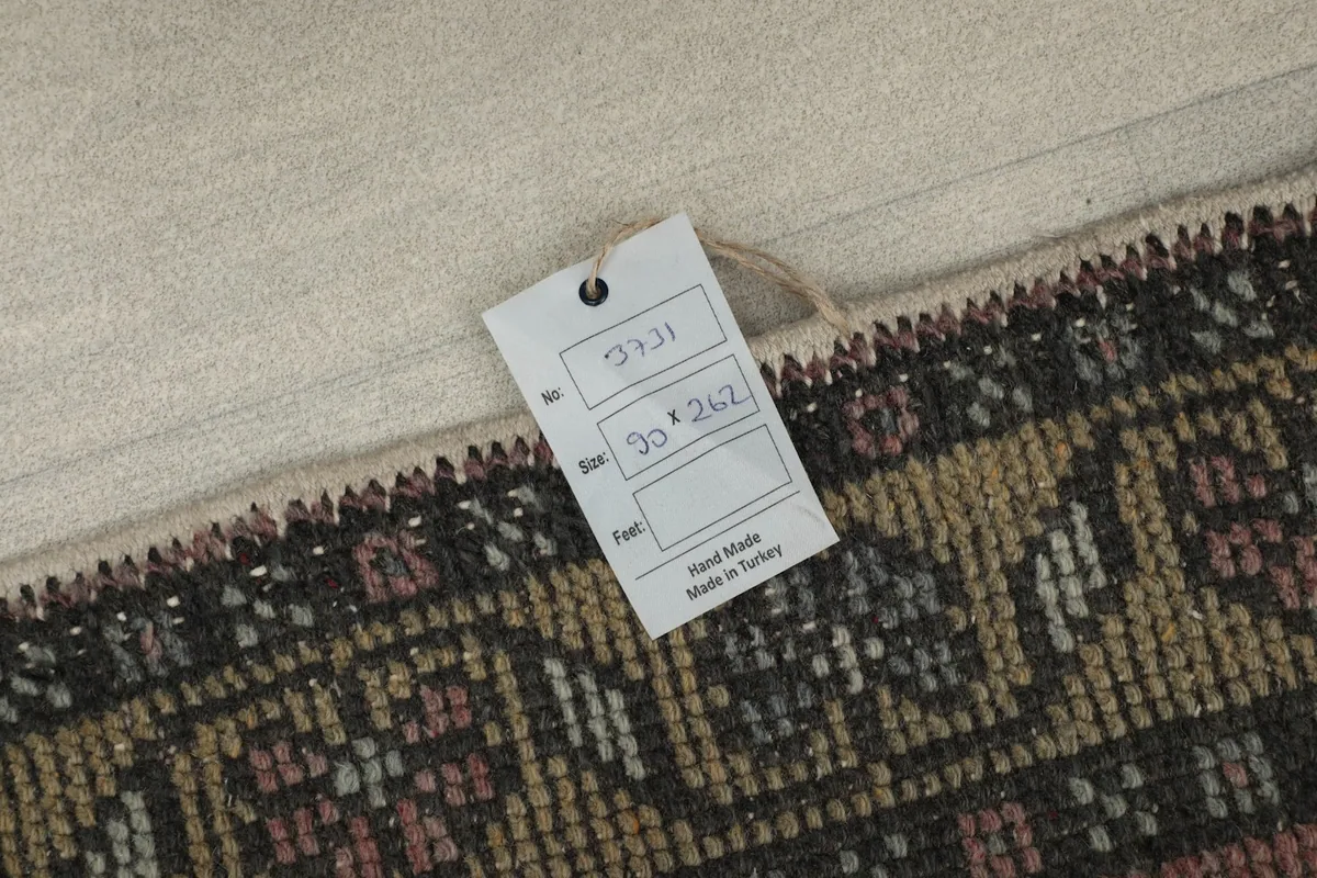 Close-up of the size tag attached to the runner, indicating dimensions and origin.