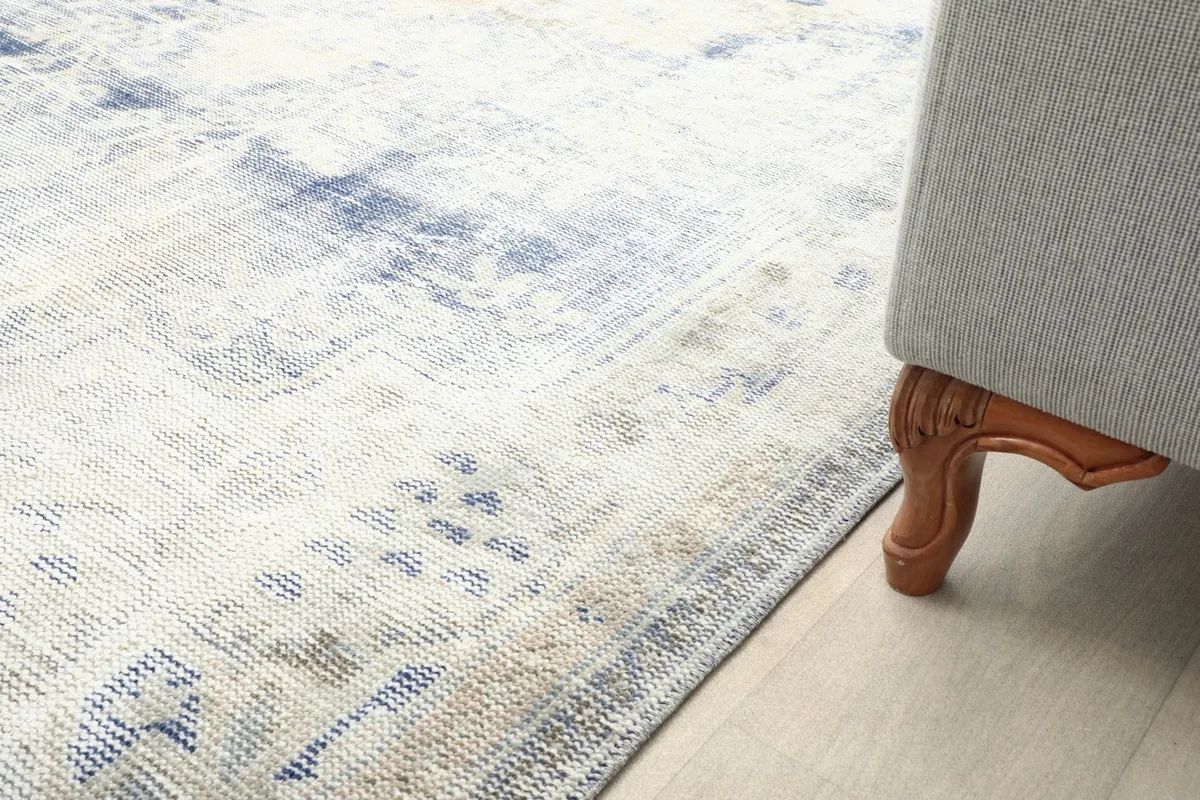 Close-up of the rug's edge next to a sofa leg, showing its integration with room furniture.