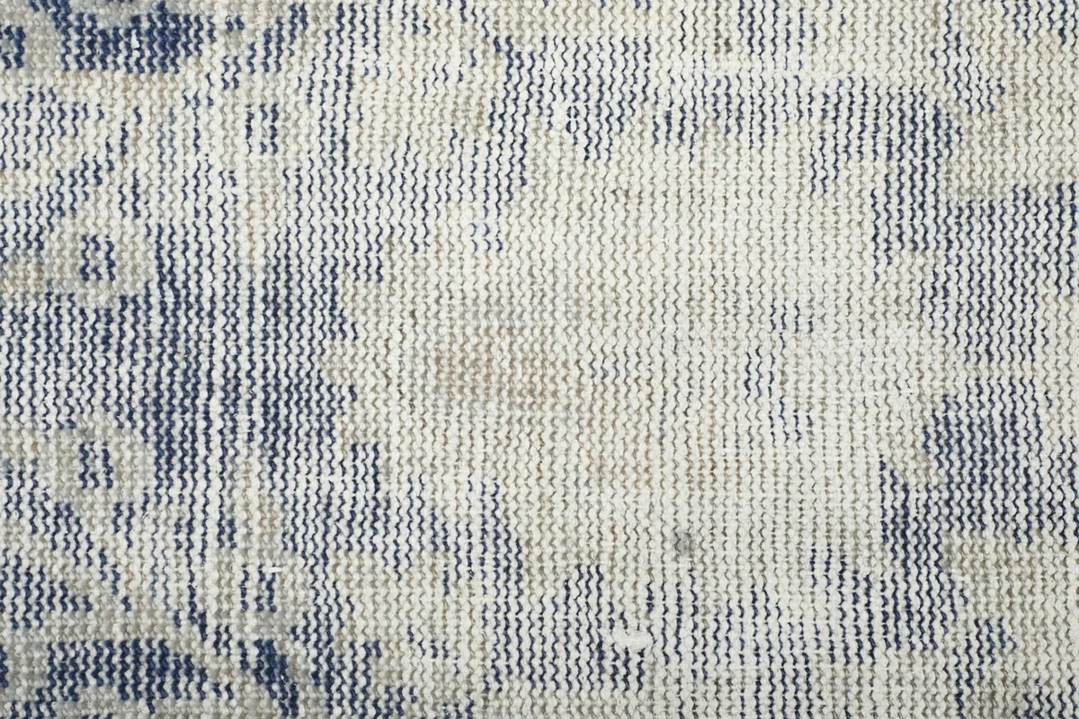 Close-up showing the low pile and texture of the hand-knotted wool, with visible cotton foundation.