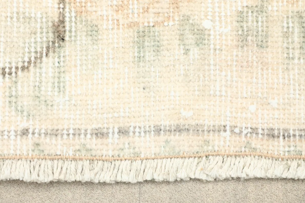 Close-up of the rug's fringe and the texture of the hand-knotted wool pile