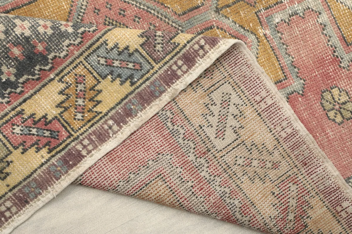 Detail of the rug's back, revealing the intricate knotting and wool pile on cotton.