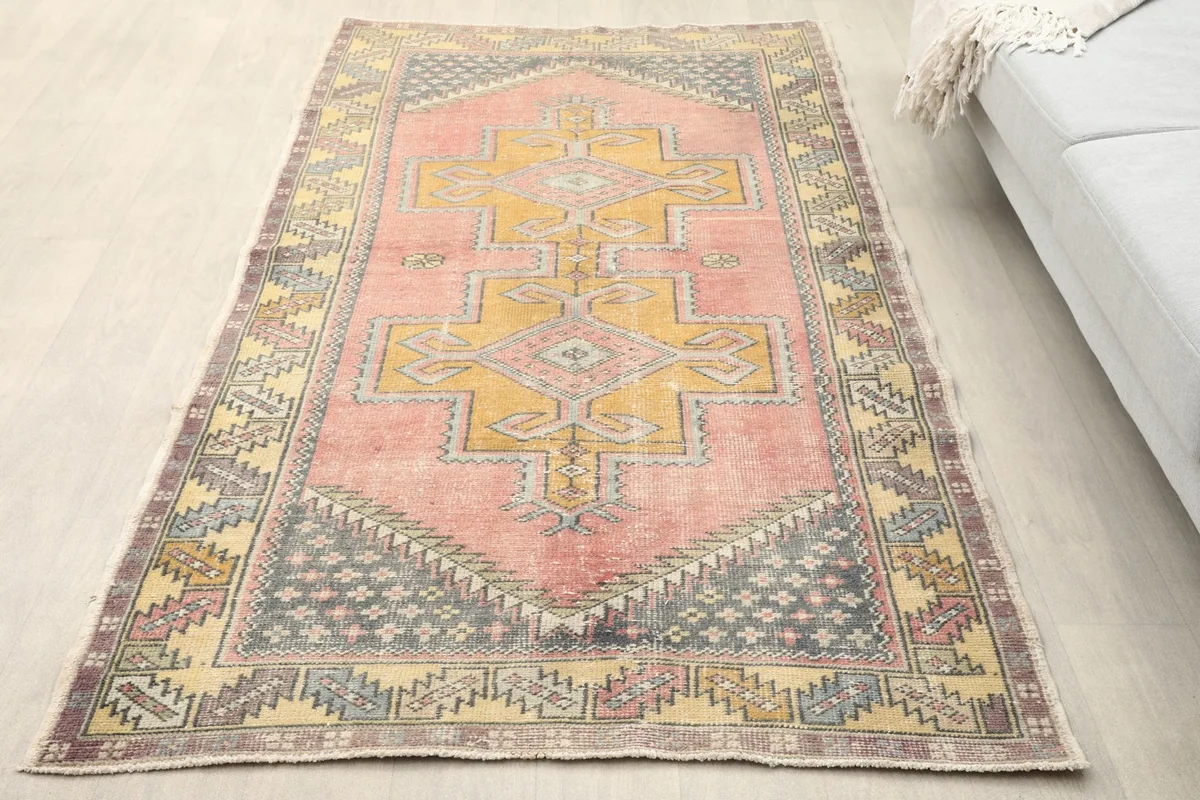 Overhead view of the vintage rose and gold rug in a room setting.