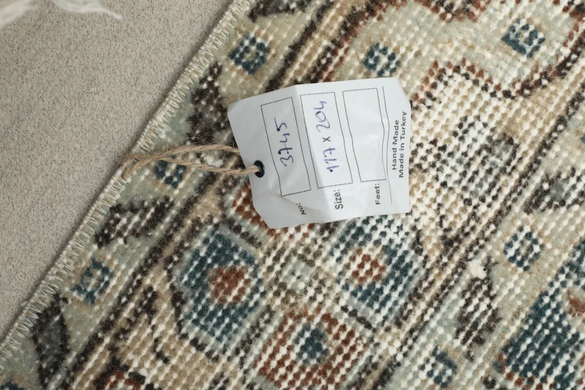 Close-up of the rug's label showing size 117 x 204 cm and origin Turkey