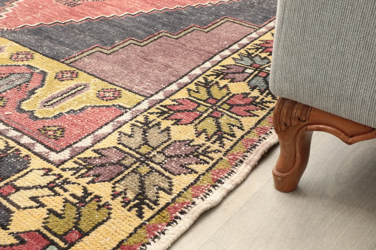 Close-up of the rug's edge and a furniture leg, illustrating the rug's low pile.