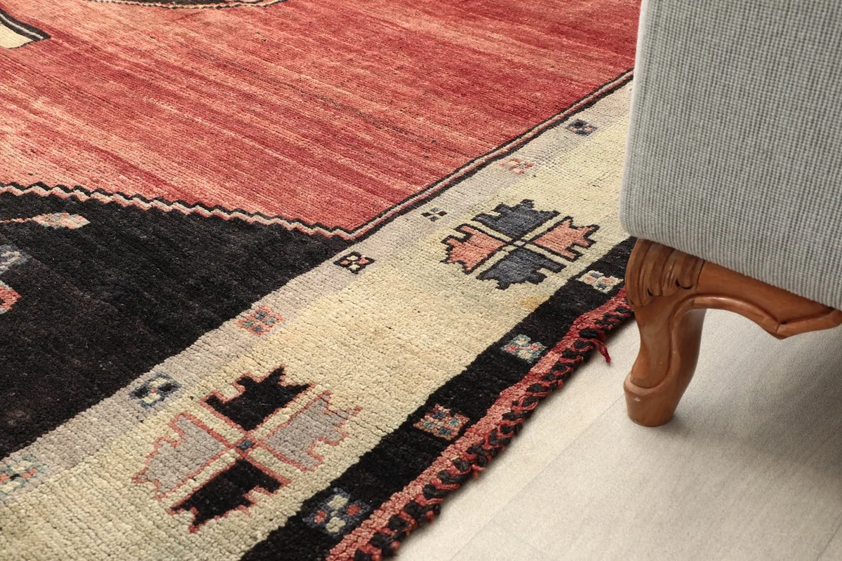 Rug corner under a sofa leg, demonstrating its placement and scale in a room