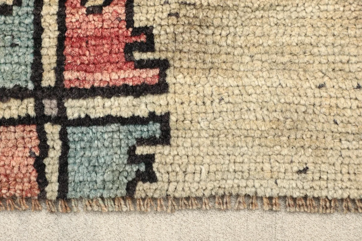 Close-up of the ivory border and geometric patterns, showing the low pile texture