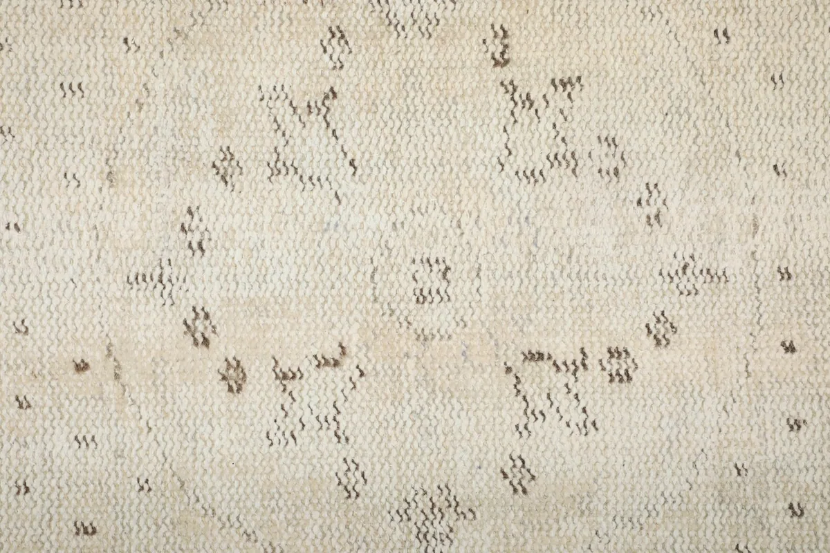 Extreme close-up showing the low wool pile and hand-knotted texture of the rug's surface.