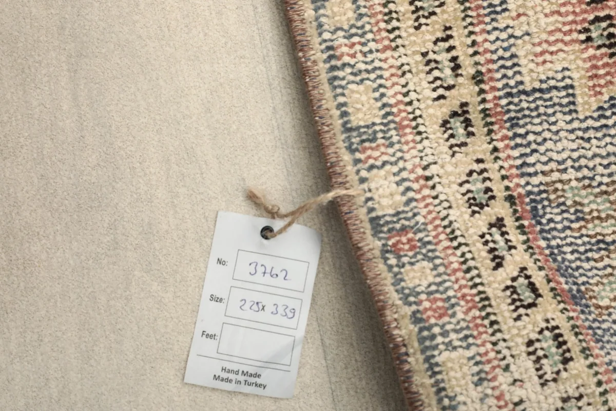 Rug tag displaying dimensions in centimeters and indicating hand-made in Turkey