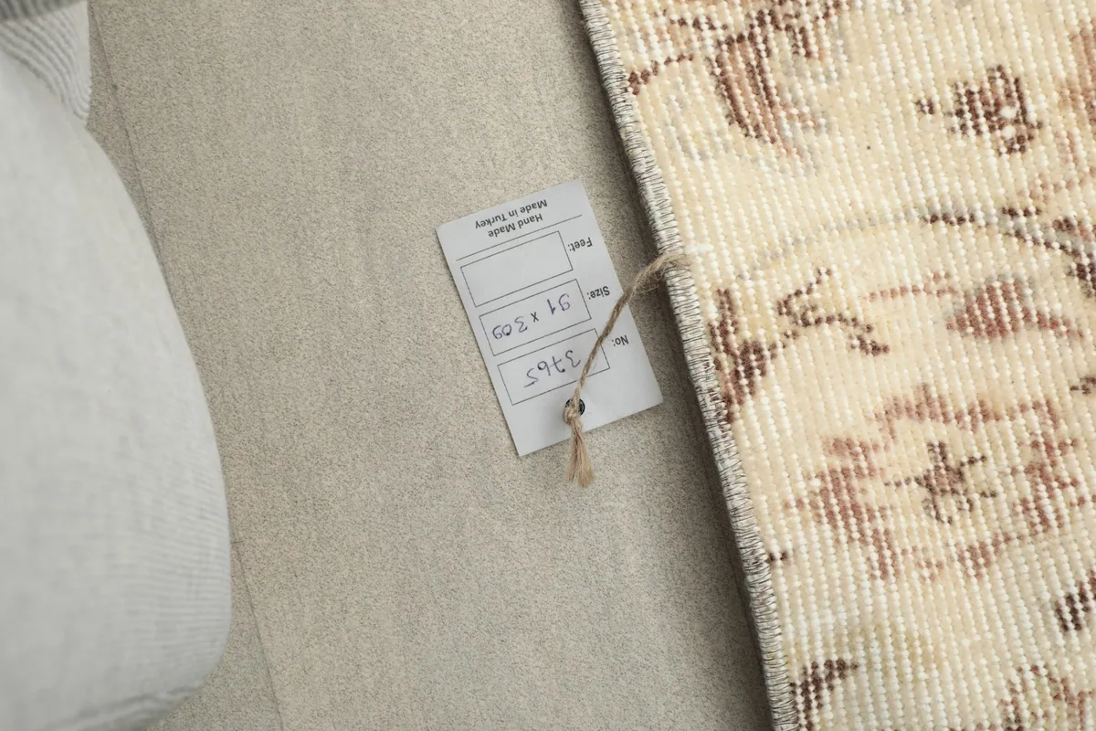 Close-up of the rug's label on the reverse side, showing dimensions and origin.
