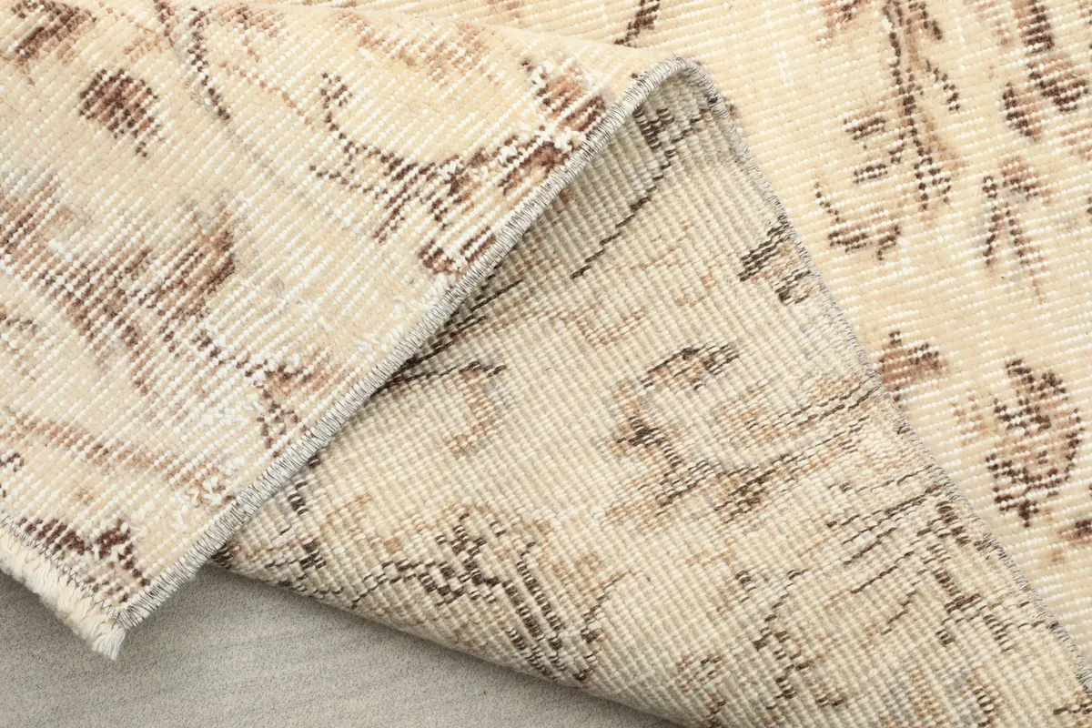 Folded section of the rug, showing the back of the hand-knotted construction and fringe details.