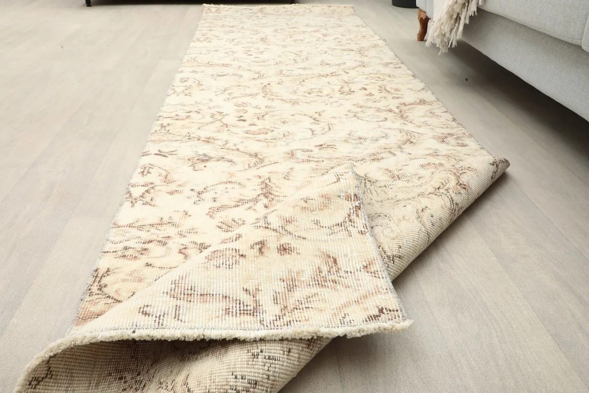 Runner rug partially unrolled on the floor, showing its length and flexibility.