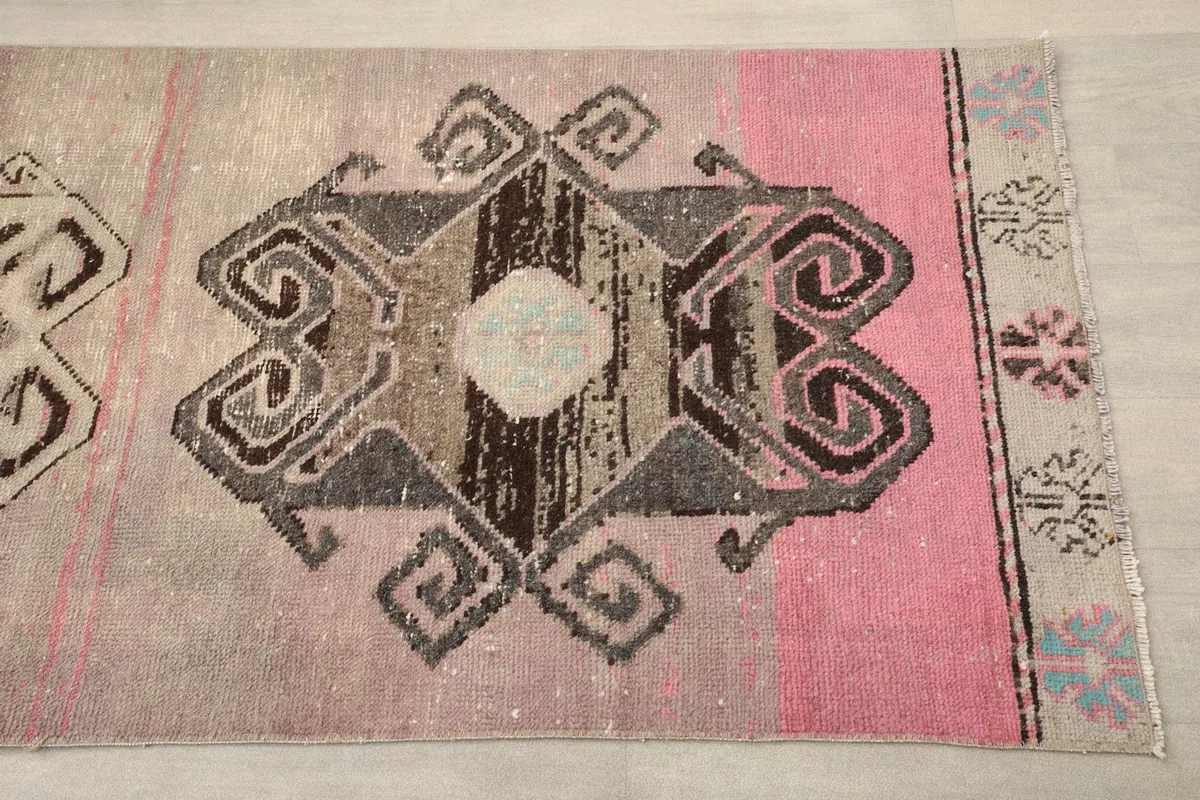 Close-up detail of one geometric motif on the rose and gray vintage runner rug