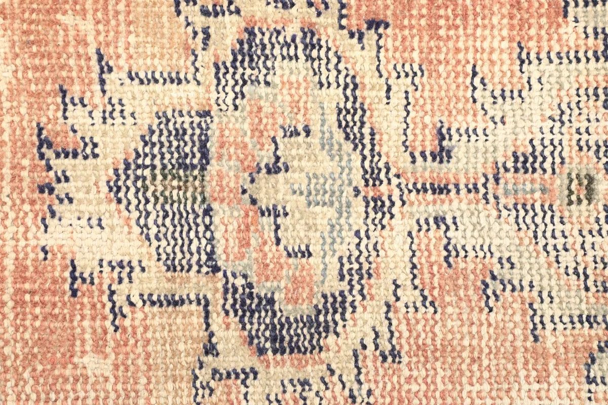 Texture detail of the low pile wool knots and colors in the rug's design