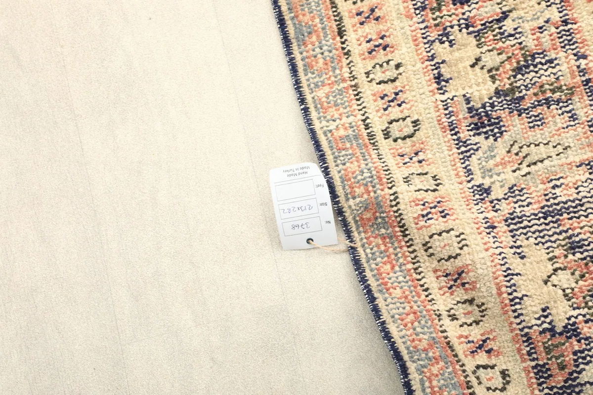 Underside of the rug near the border, showing the hand-knotted construction and label