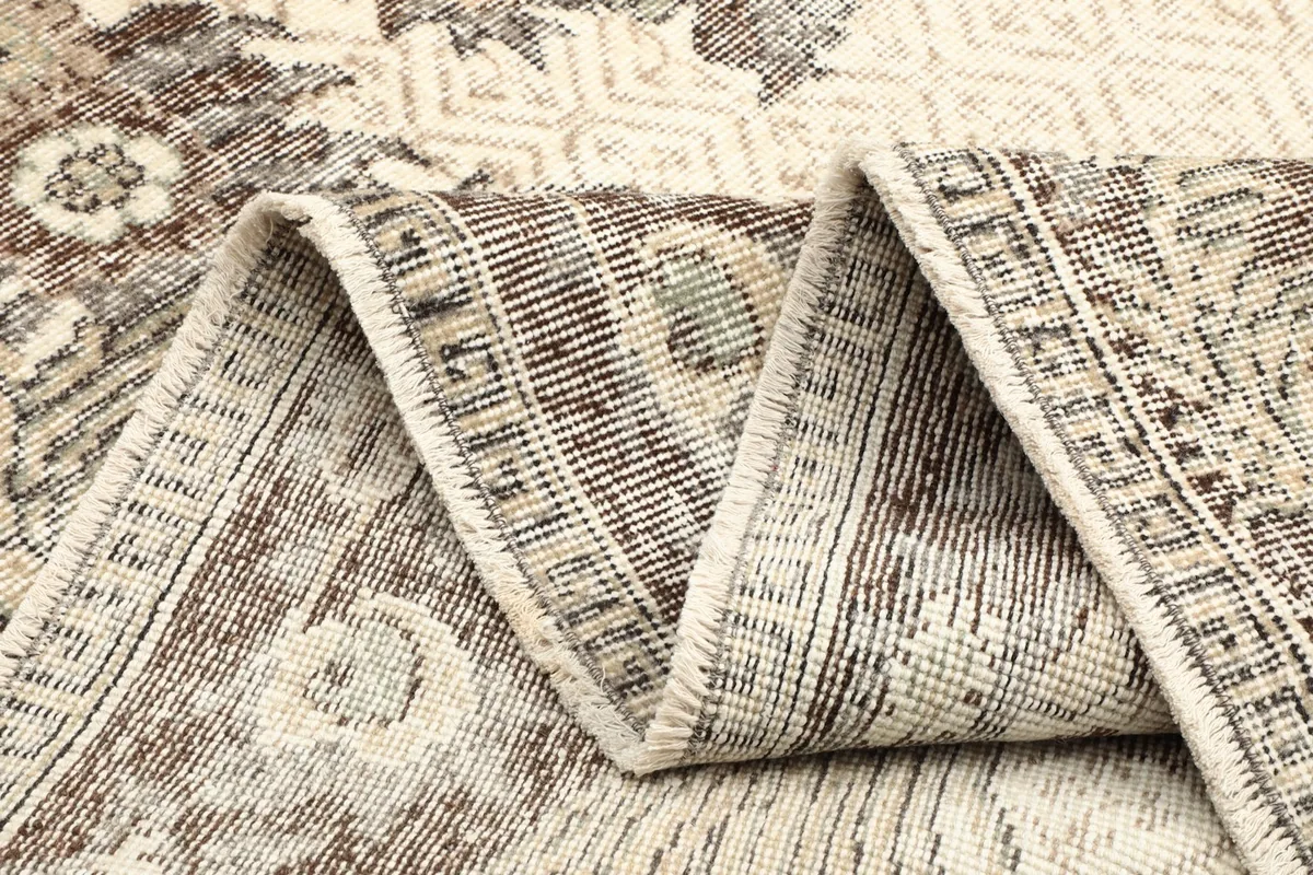 Close-up of the rug's fold, revealing the wool pile and cotton foundation texture