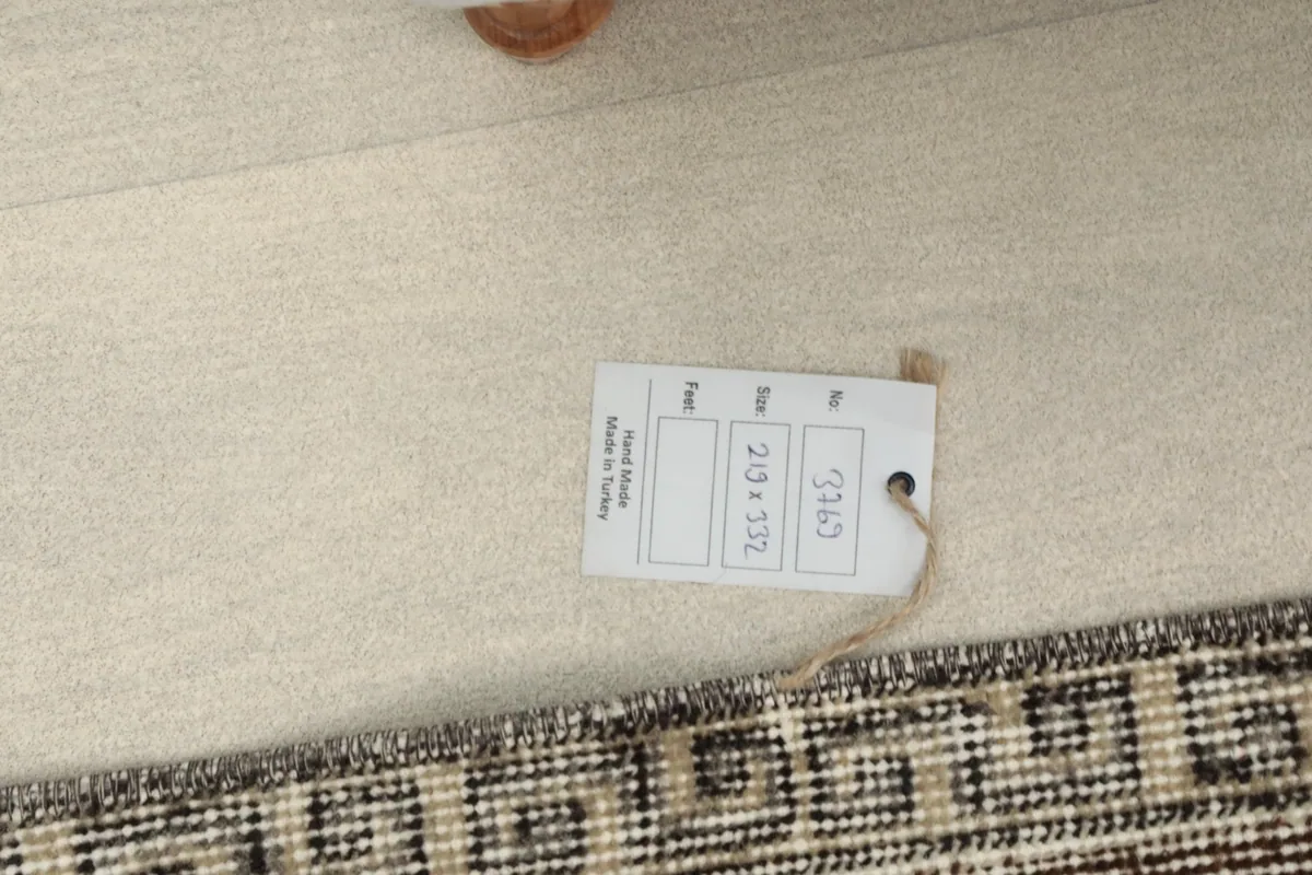 Product tag displaying the rug's size 219x332 cm and origin on the rug's back