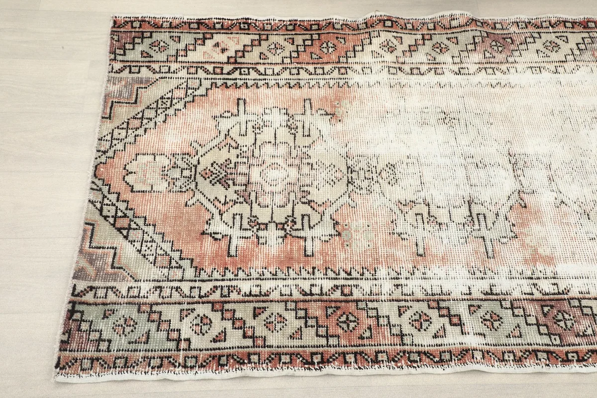 Detail view of the central medallion-like motif and surrounding rust and cream patterns