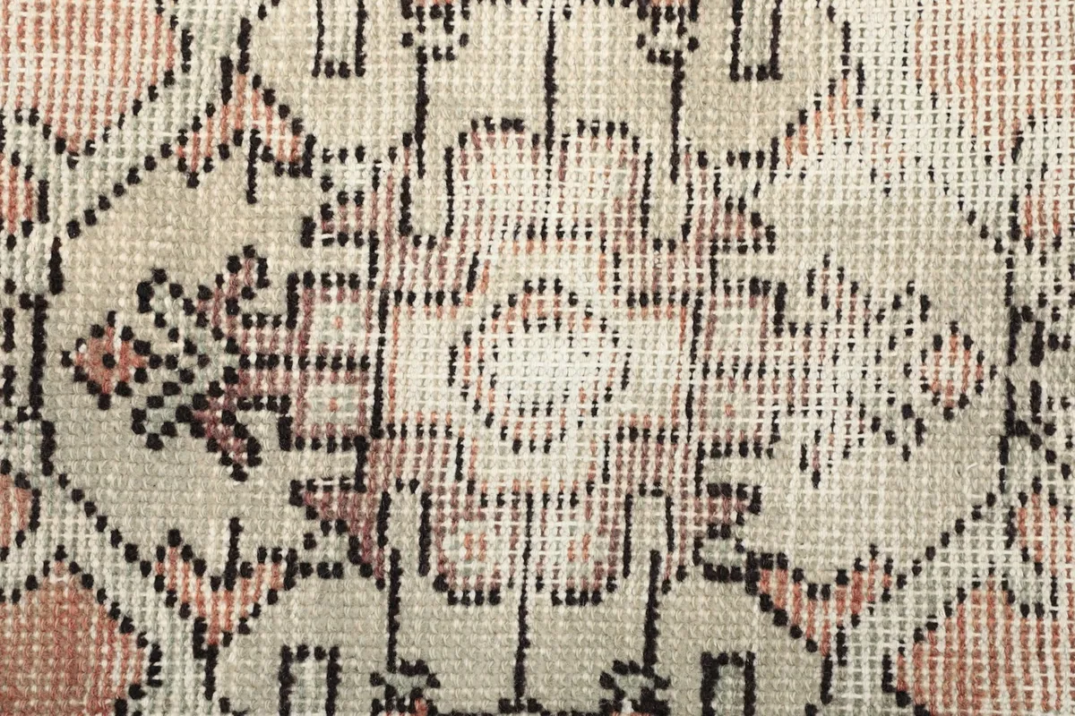 Macro view of the low wool pile and individual knots of the vintage rug