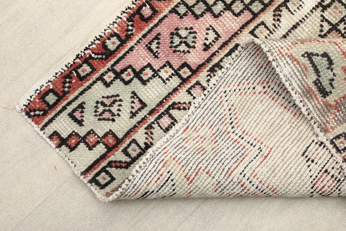 Corner of the runner folded to show the cotton foundation and back of the hand-knotted construction