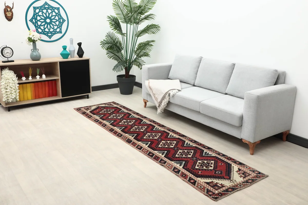 Long runner rug placed in a room setting next to a sofa and cabinet