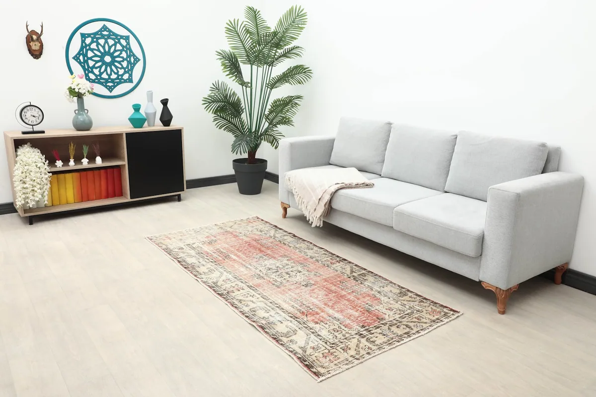 Vintage rose and beige rug in a modern living room setting with a gray sofa