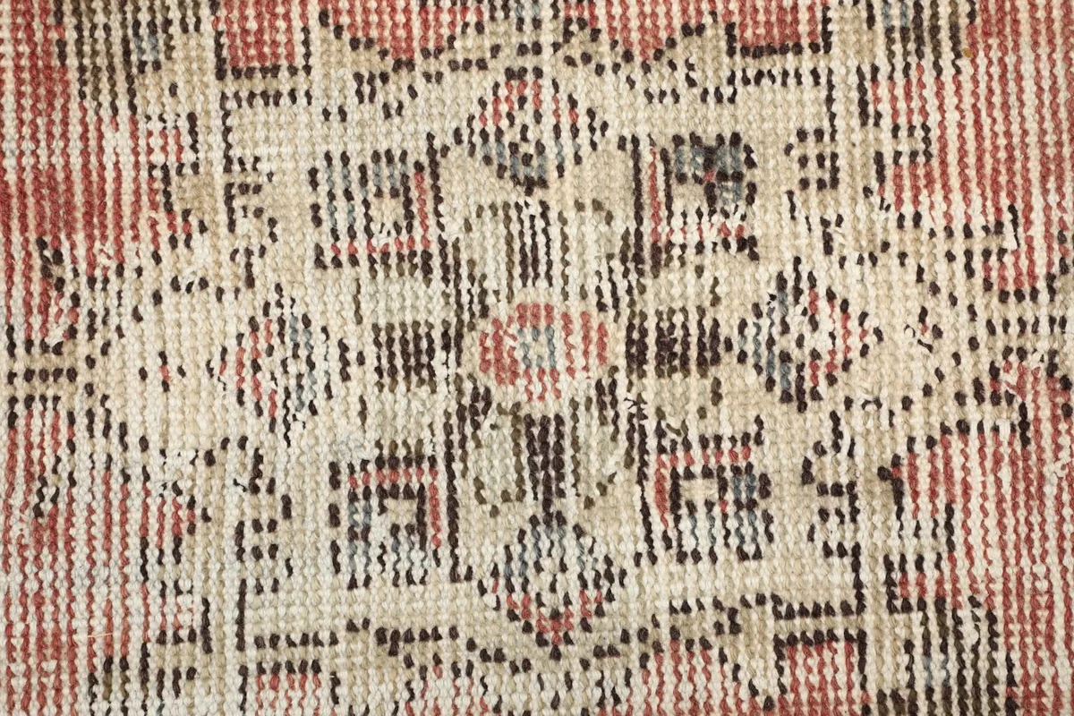 Close-up texture of the low wool pile and hand-knotted details of the rug