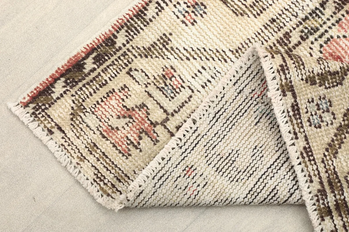 Folded corner of the rug revealing the backside of the hand-knotted wool and cotton foundation