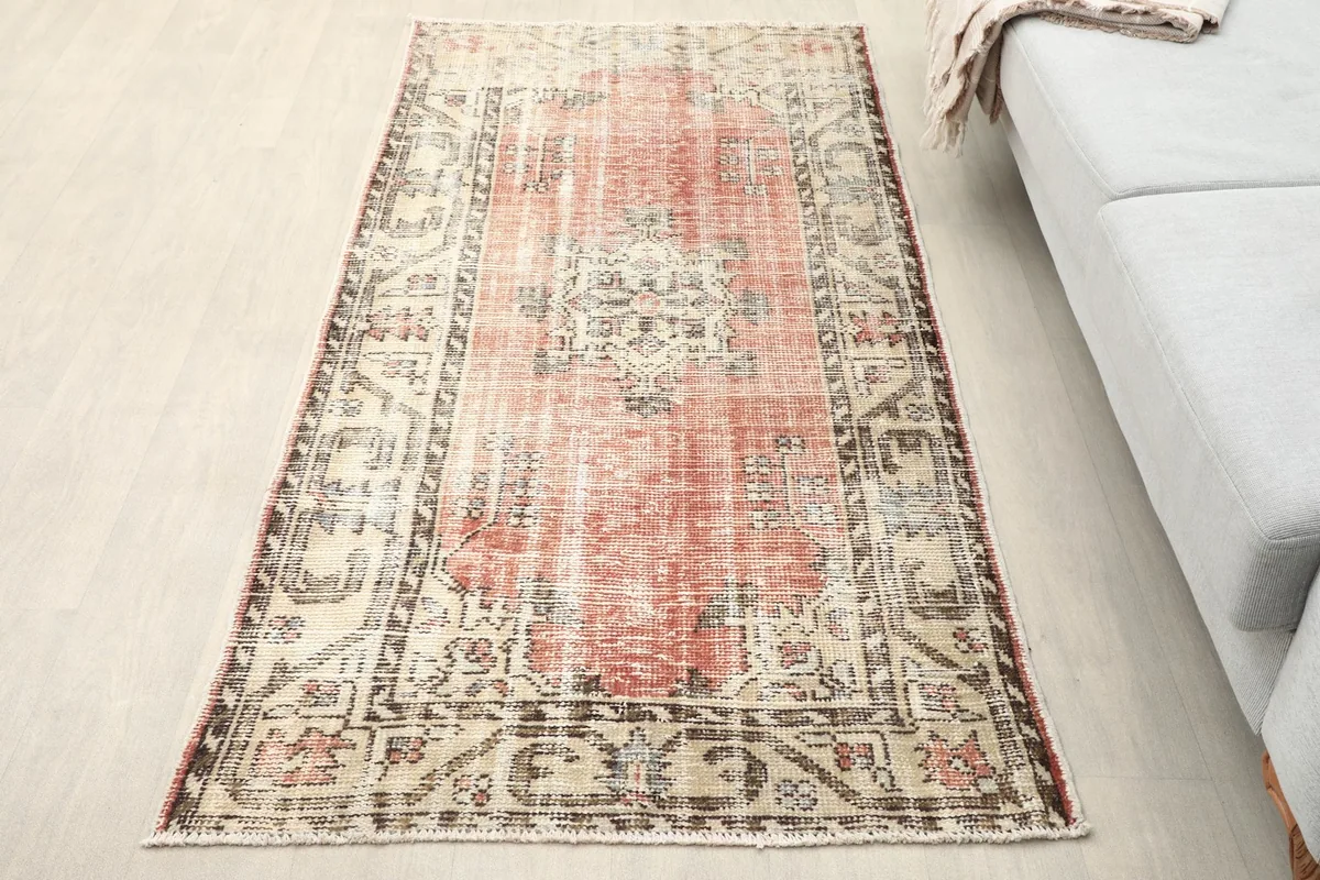 Overhead view of the rose and beige vintage rug placed on a light floor