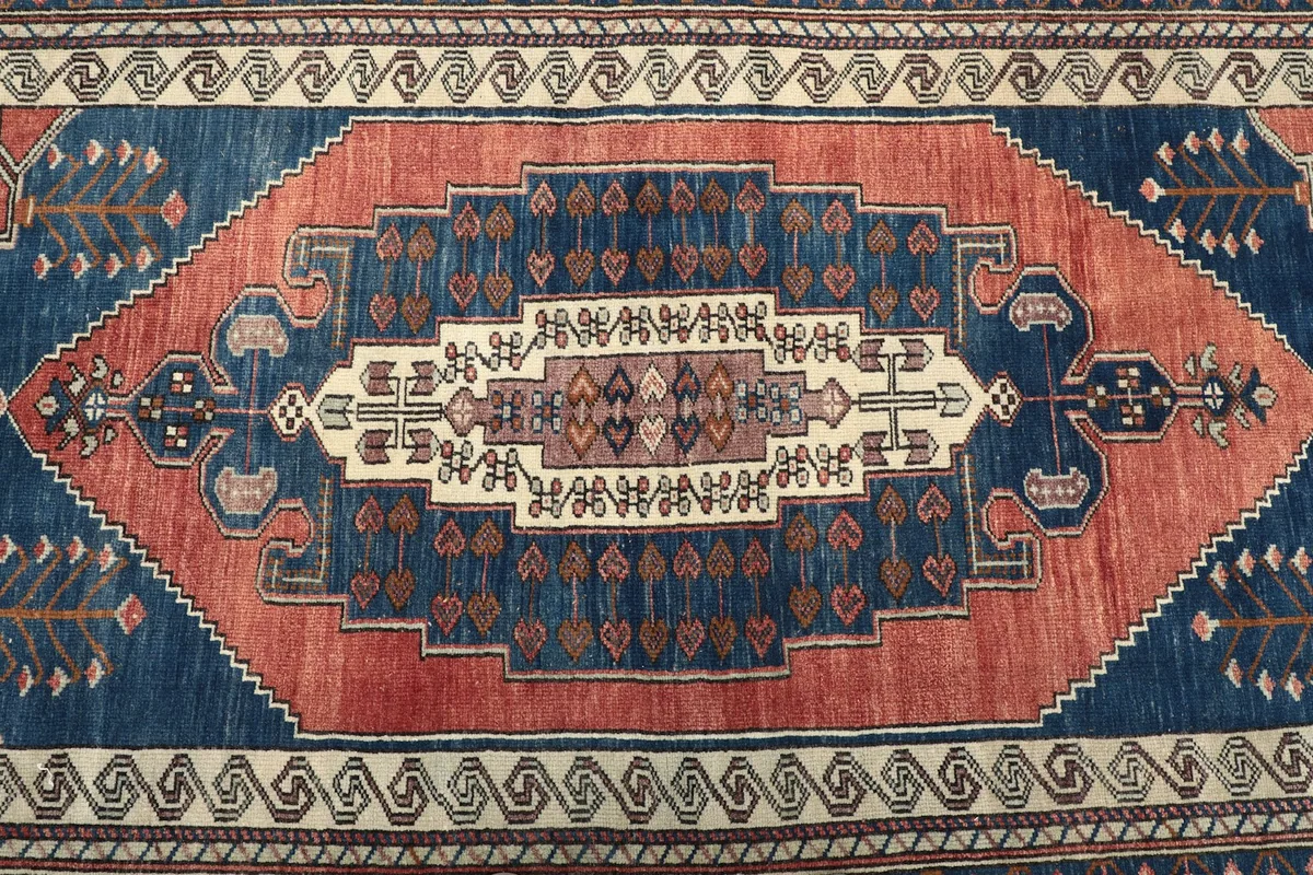 Close-up of the central rust medallion and surrounding blue field motifs