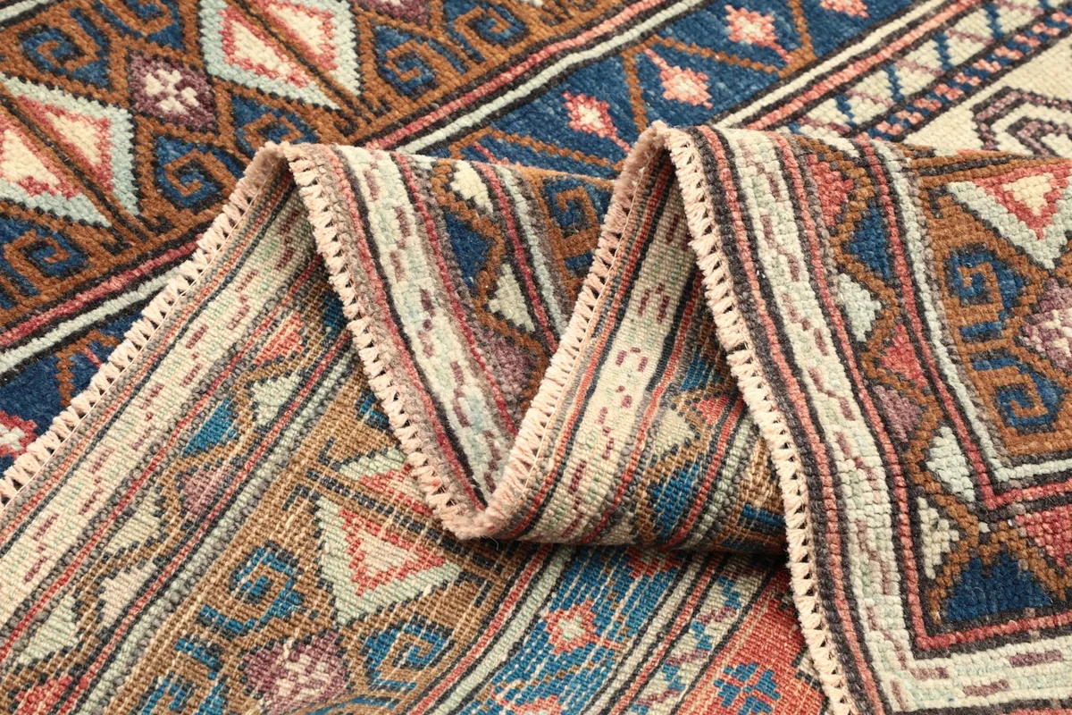 Close-up of the rug's border folded, highlighting texture and patterns