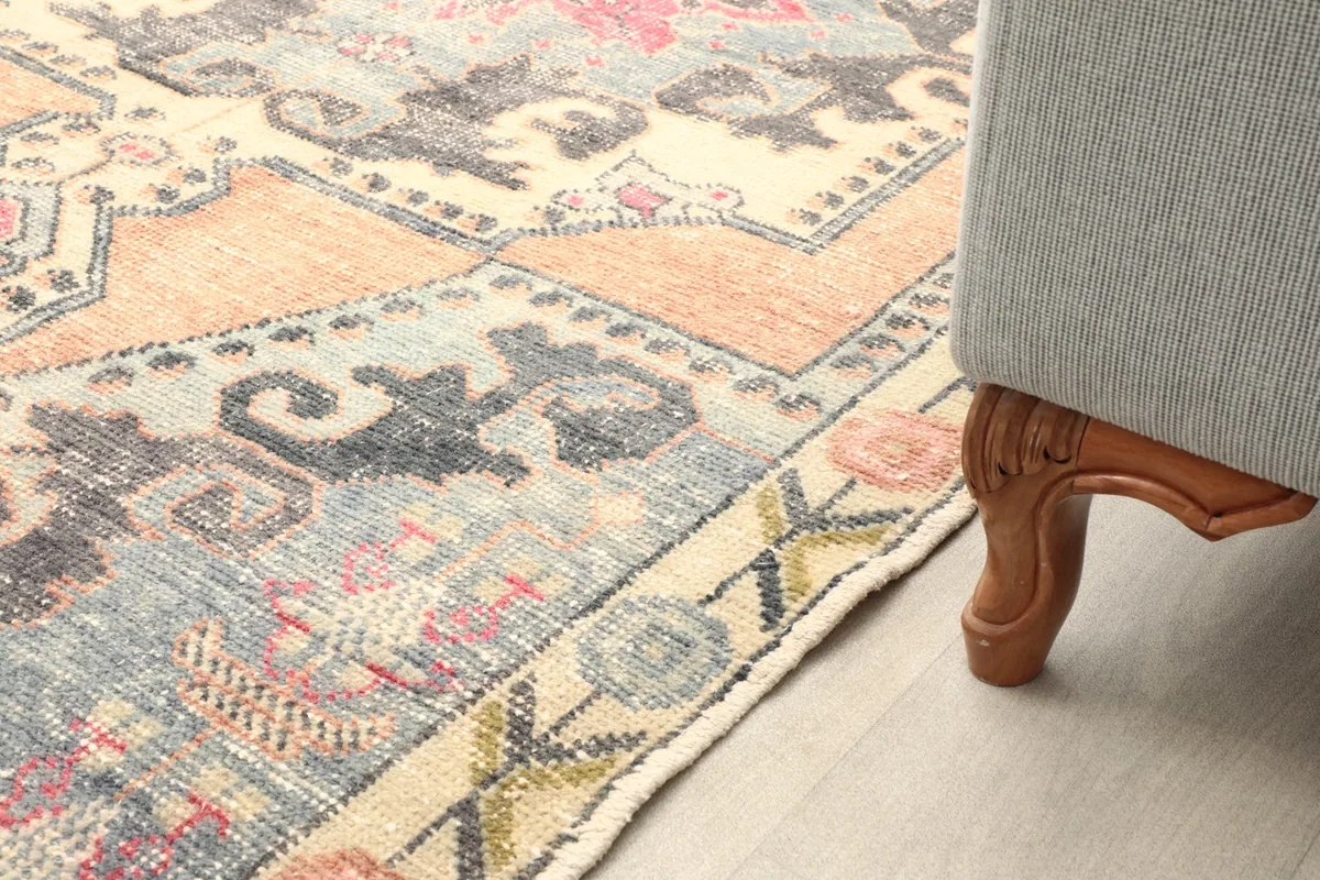 Rug placed under the leg of a sofa, showcasing its size and how it fits into a living space