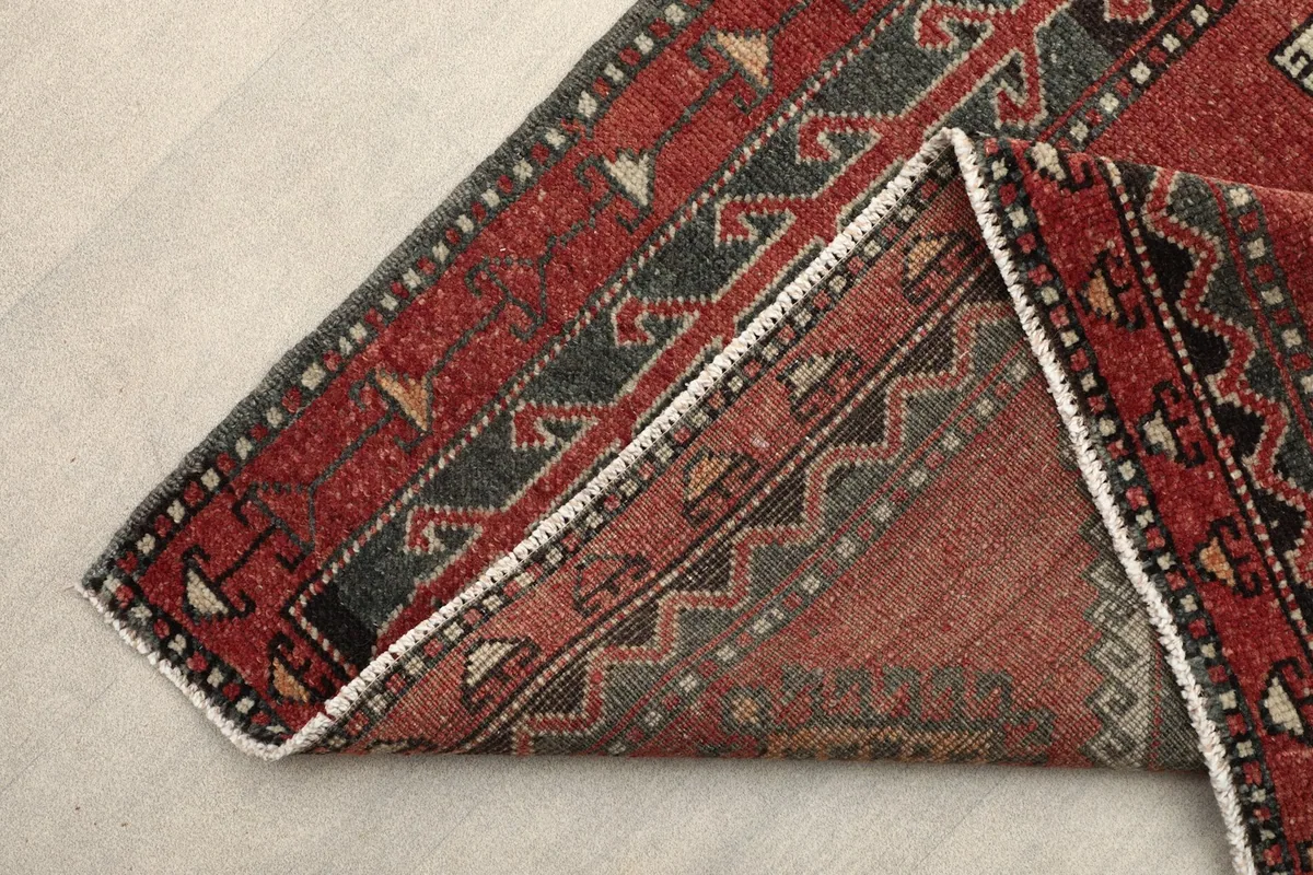 Folded edge of the rug showing the wool pile and cotton foundation