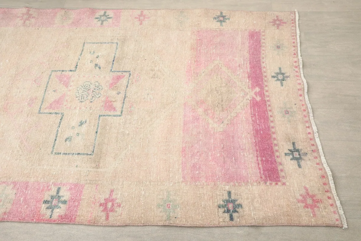 Close-up of the runner's beige field, rose border, and blue geometric cross motif