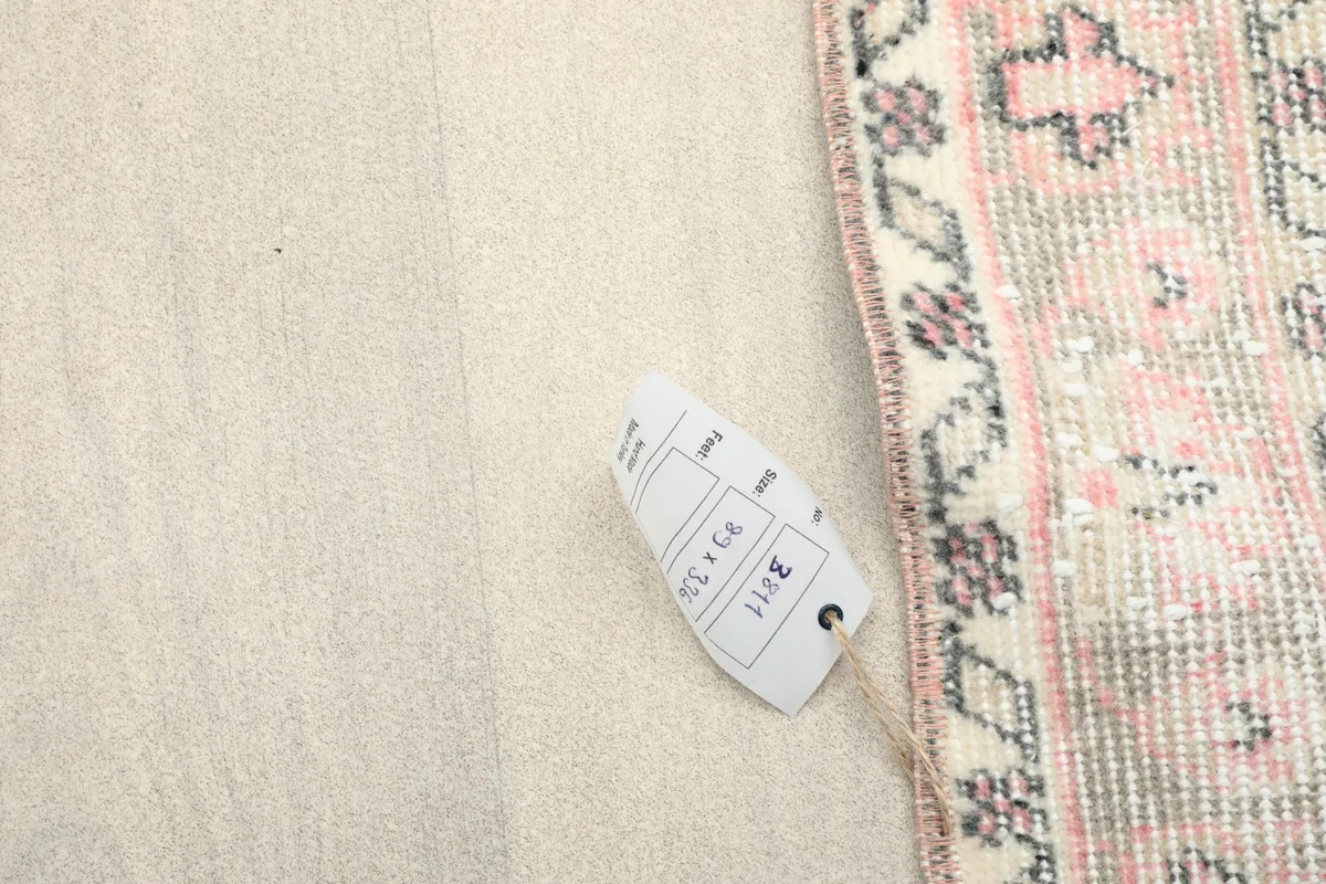 Rug tag displaying the size 2'11" x 11'0" (89 x 336 cm) next to the rug's edge