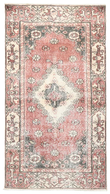 Top view of the distressed rose, charcoal, and ivory hand-knotted Anatolian rug on a white background.