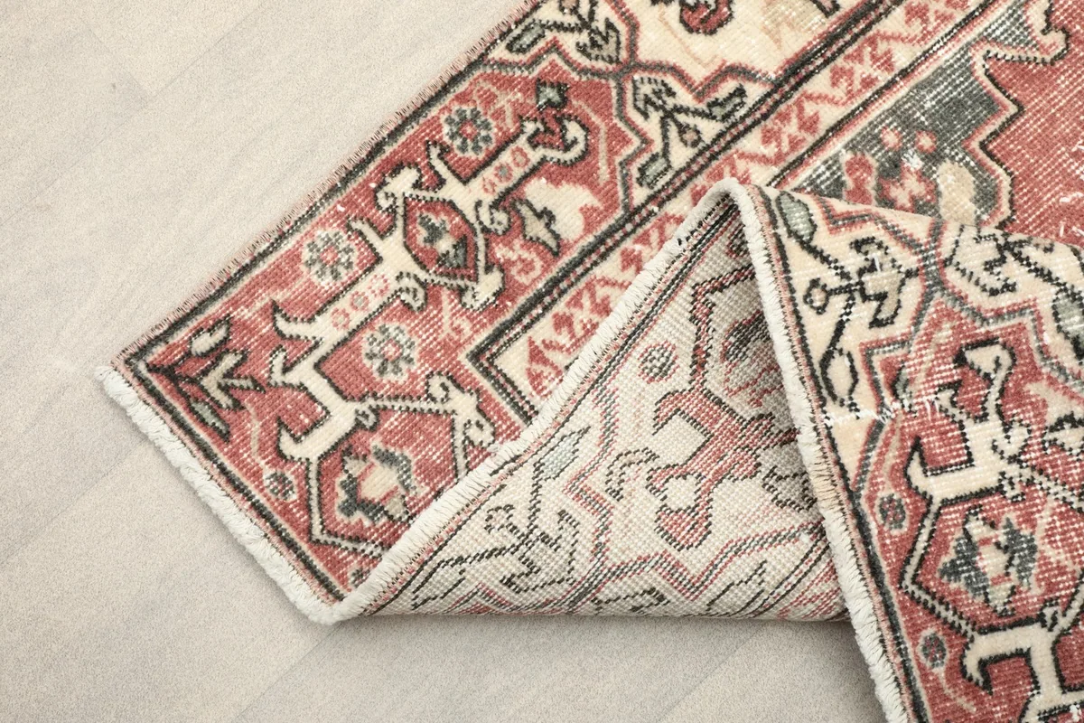 View of the rug folded back to show the reverse side of the hand-knotted wool pile and cotton foundation.